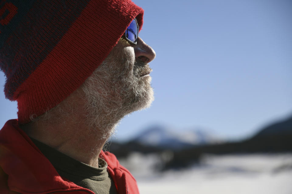 In this photo taken Jan. 7, 2020, British artist Simon Beck takes a break from creating a large geometrical design on a reservoir near Silverthorne, Colo. He and a group of volunteers spent more than a dozen hours on a design that spanned the length of about two soccer fields. (AP Photo/Thomas Peipert)