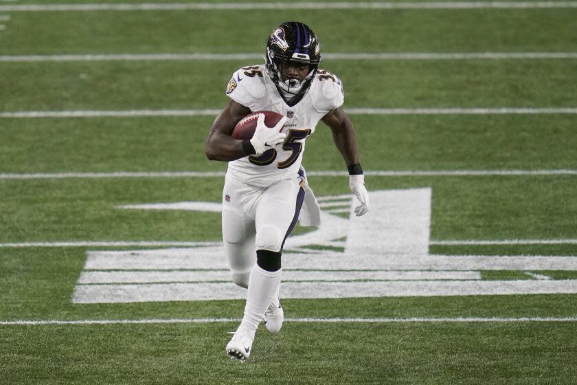 Baltimore Ravens running back Gus Edwards runs win open field.