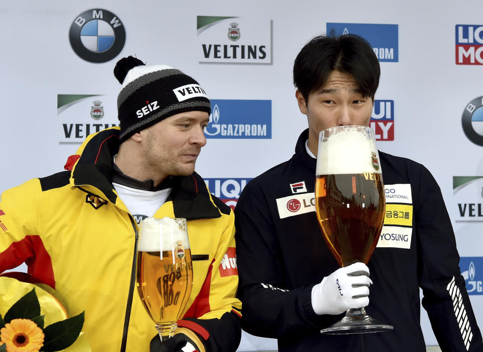 Yun Sung Bin from South Korea zips from a giant glass of beer after winning the men's Skeleton world cup in Winterberg, Germany, Sunday, Jan.5, 2019. Germany's Axel Jungk at left.(Caroline Seidel/dpa via AP)