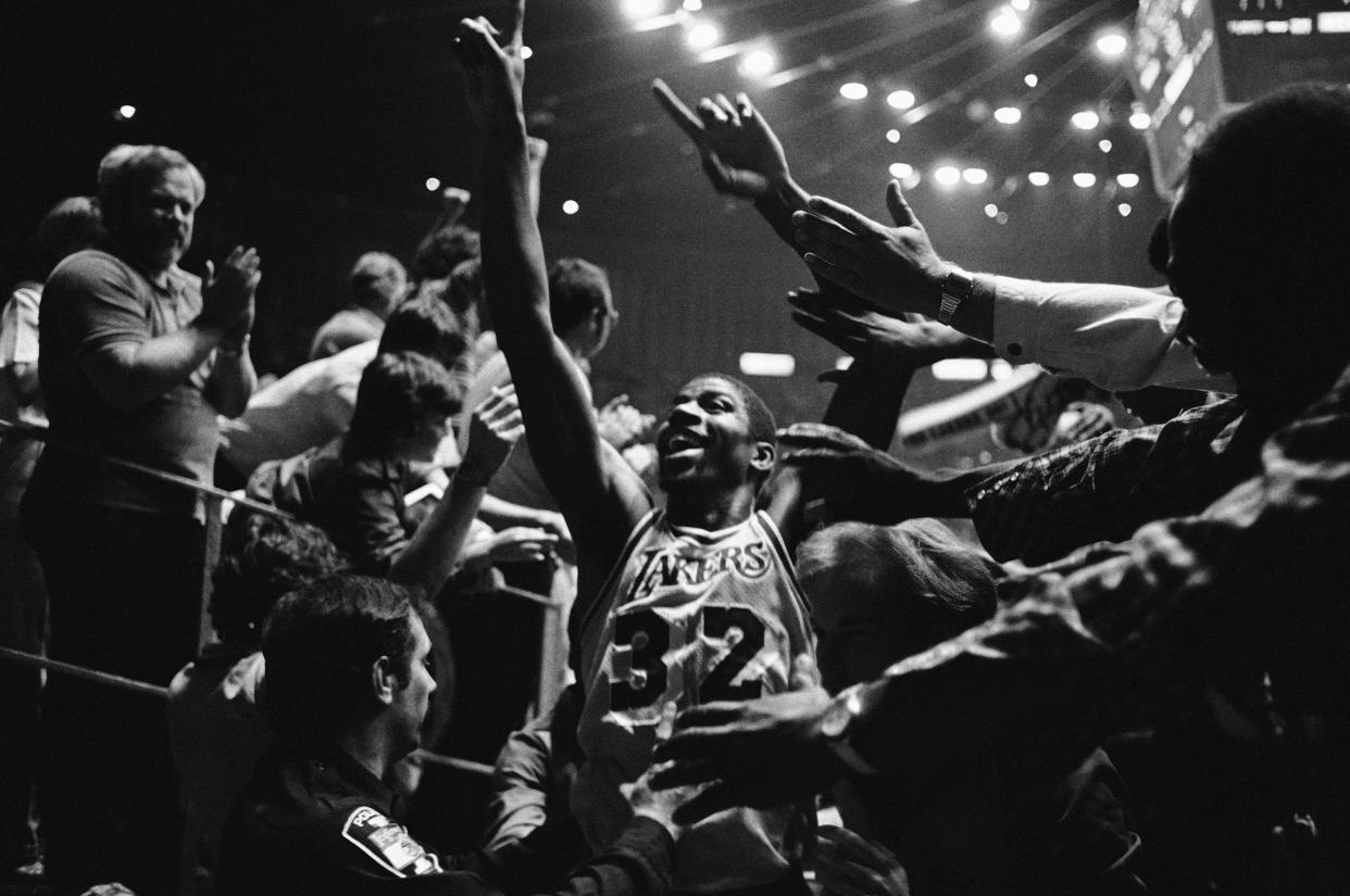 Los Angeles Lakers' Magic Johnson raises his hands in triumph as he acknowledges the crowd, Tuesday, June 8, 1982 in Los Angeles after the Lakers defeated the Philadelphia 76ers, 114-104, to take the NBA Playoff Series four games to two. (AP Photo/Lennox McLendon)