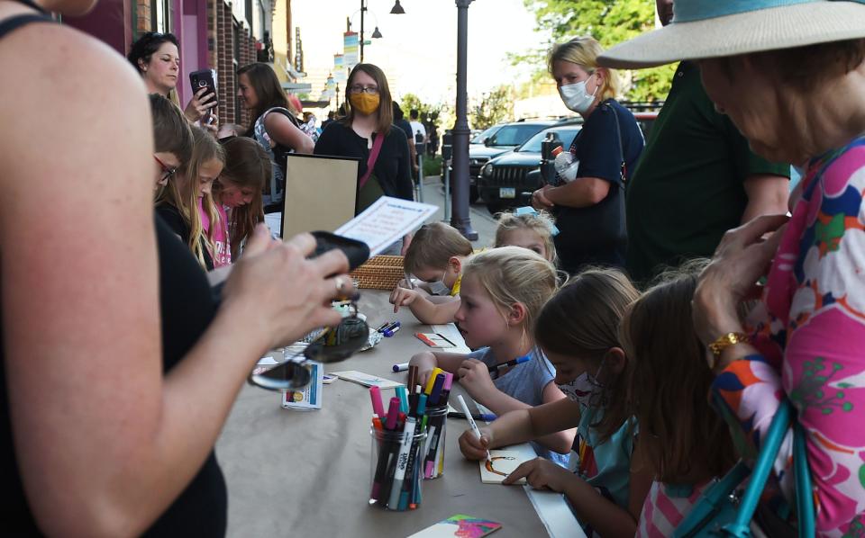 Children draw at a table on Main Street at a booth hosted by Iowa State University's Memorial Union Workspace during the Art Walk in 2021 in downtown Ames.