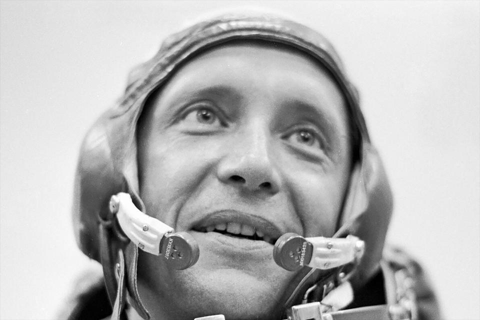 black and white headshot of a man wearing a weird skull cap