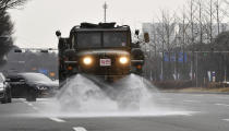 In this Feb. 11, 2020 photo, Soldiers in the military truck, spray disinfectant as a precaution against the COVID-19 on the street in Gwangju, South Korea. The U.S. and South Korean militaries, used to being on guard for threats from North Korea, face a new and formidable enemy that could hurt battle readiness: a virus spreading around the world that has infected more than 1,200 people in South Korea. (Shin Dae-hee/Newsis via AP)