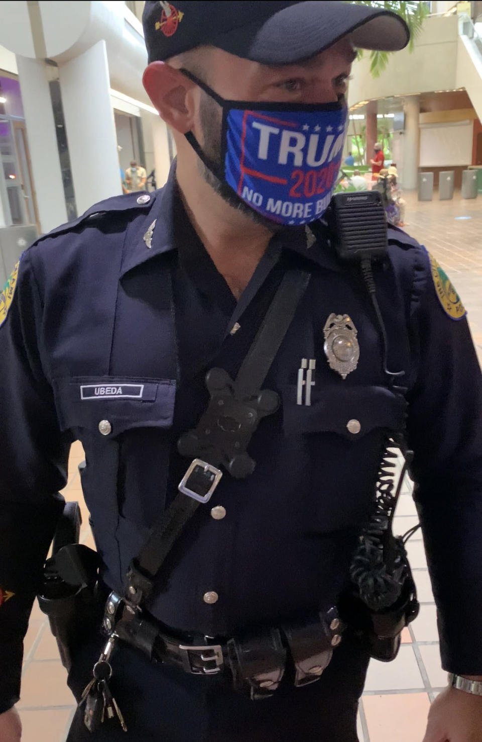 A Miami police officer wearing a Trump campaign mask. (Steve Simeonidis via Twitter)
