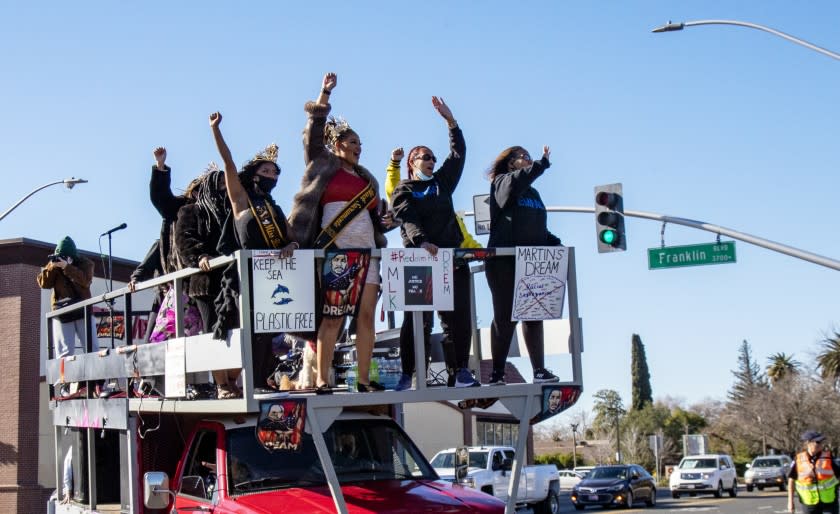 SACRAMENTO, CA - JANUARY 18, 2021: Participants cheer while riding atop a flatbed truck during a car caravan honoring Martin Luther King on his holiday January 18, 2021 in Sacramento, California. Racial justice moments were at a pinnacle across the country and in California 6 months ago, but due to Covid some far right threats have been silenced.(Gina Ferazzi / Los Angeles Times)