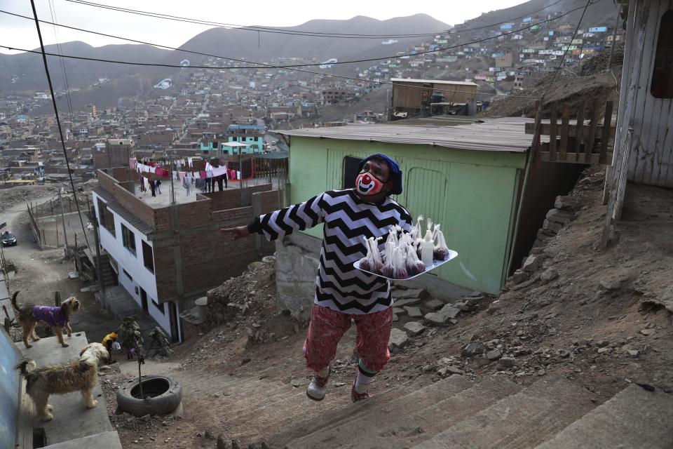 Circus clown Jhona Zapata, whose clown name is "Jijolin," offers caramelized apples for sale during the lockdown to curb the spread of COVID-19 in a poor neighborhood on the outskirts of Lima, Peru, Wednesday, Aug. 5, 2020. Zapata, 35, is selling circus food to help his family survive the economic shutdown. (AP Photo/Martin Mejia)