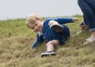 <p>Prince George, 11 months, slides down a hill while watching his dad Prince William and uncle Prince Harry play a charity match at the Beaufort Polo Club.</p>