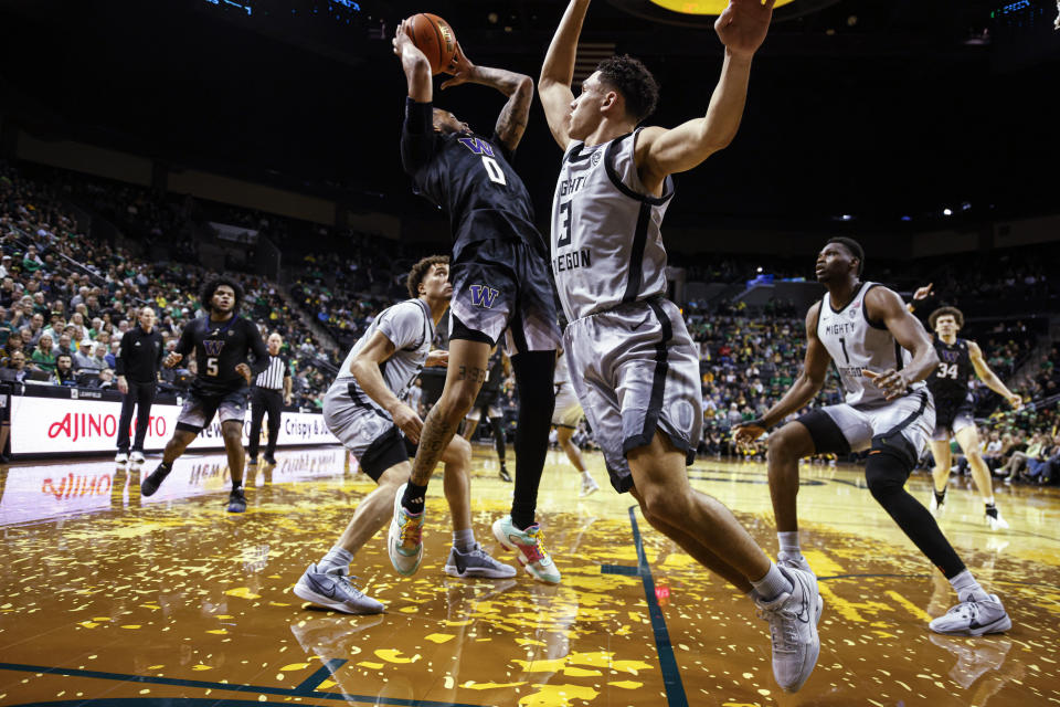 Washington guard Koren Johnson (0) shoots against Oregon guard Jackson Shelstad (3) during the second half of an NCAA college basketball game in Eugene, Ore., Thursday, Feb. 8, 2024. (AP Photo/Thomas Boyd)