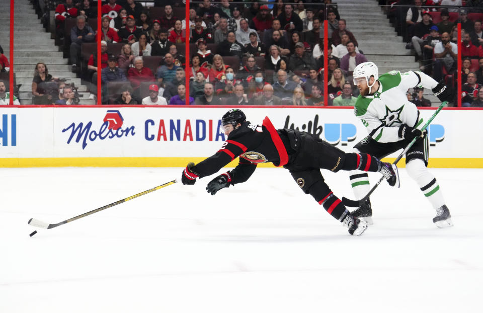 Ottawa Senators right wing Alex DeBrincat (12) is tripped by Dallas Stars defenseman Jani Hakanpaa (2) on a breakaway during second-period NHL hockey game action in Ottawa, Ontario, Monday, Oct. 24, 2022. (Sean Kilpatrick/The Canadian Press via AP)