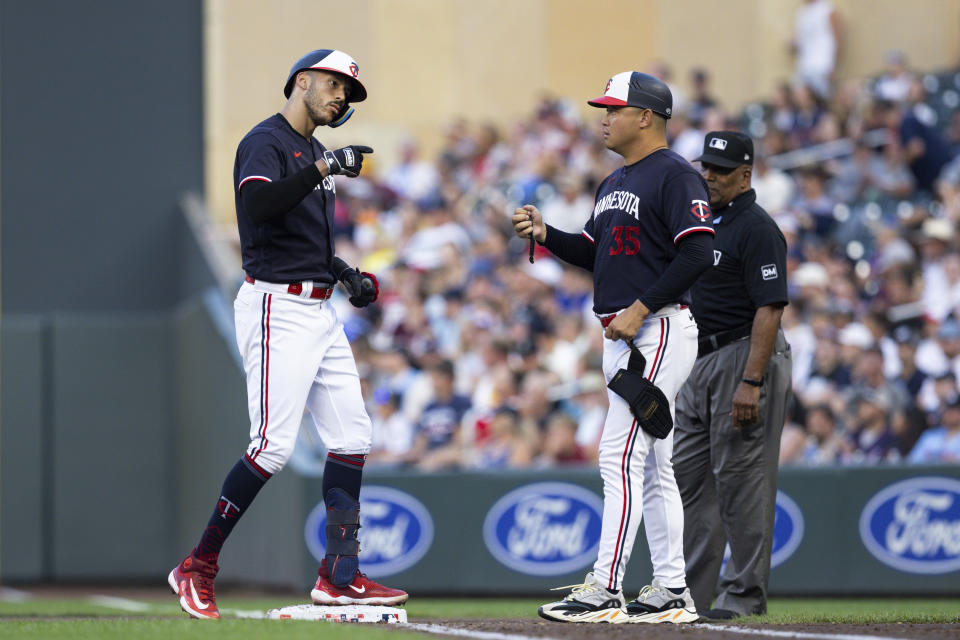 Minnesota Twins' Carlos Correa celebrates with first base coach Hank Conger (35) after hitting a single against the Pittsburgh Pirates during the sixth inning of a baseball game Saturday, Aug. 19, 2023, in Minneapolis. (AP Photo/Bailey Hillesheim)