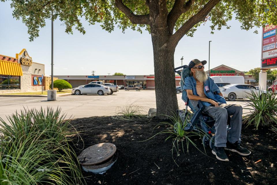 Randy Twede, 70, sits in the shade while waiting for the bus on July 10, 2023, in Austin, Texas. ‘These temperatures are no joke. I’m just trying to survive, that’s all,’ he told the photographer. <a href="https://www.gettyimages.com/detail/news-photo/randy-twede-sits-in-the-shade-while-waiting-for-the-bus-on-news-photo/1531835627" rel="nofollow noopener" target="_blank" data-ylk="slk:Brandon Bell/Getty Images;elm:context_link;itc:0;sec:content-canvas" class="link ">Brandon Bell/Getty Images</a>