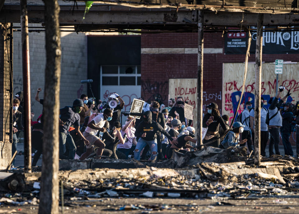 Protesters skirmish with the National Guard near the 3rd Precinct before heading down Lake St. towards the 5th Precinct in Minneapolis, Minn., Friday, May 29, 2020. Peaceful protests turned increasingly violent in the aftermath the death of George Floyd during an arrest. Mayor Jacob Frey ordered a citywide curfew at 8 p.m. local time, beginning on Friday. (Richard Tsong-Taatarii/Star Tribune via AP)