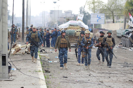 Federal police members carry their weapons during a battle with Islamic State militants in Mosul, Iraq March 28, 2017. REUTERS/Khalid al Mousily