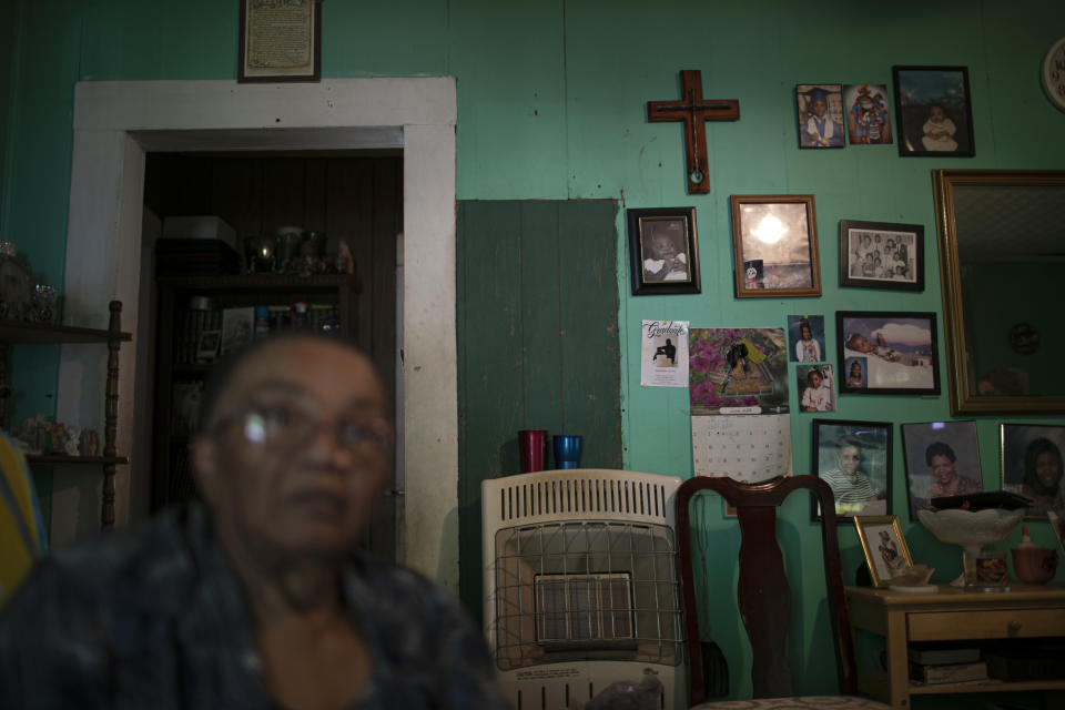 Lou Alice Bolden with a crucifix and framed photographs in her home in Greenwood, Miss., Saturday, June 8, 2019. Known as "Miss Lou," Bolden has three grandsons who say they were sexually abused at a local Catholic grade school. (AP Photo/Wong Maye-E)