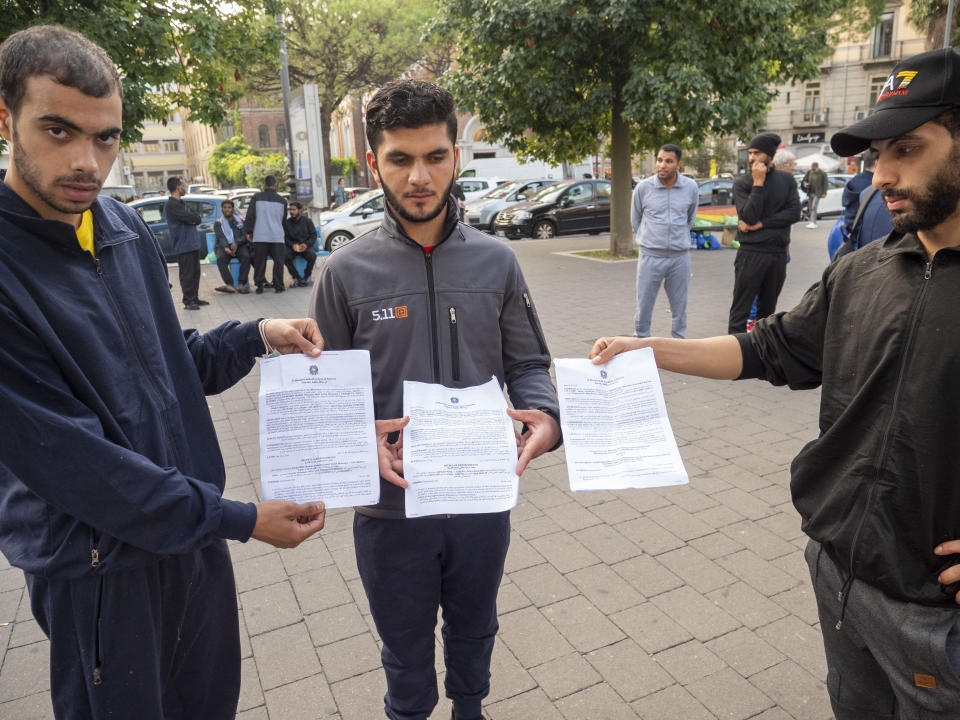 Refugees from Syria show their expulsion orders in front of Salerno's railway station, southern Italy, Monday, Oct. 23, 2023, where they were brought after being rescued from the sea on Oct. 6 by the humanitarian ship Geo Barents in the Mediterranean Sea some 30 miles off Libya. Badly advised by relatives and friends, misled by insufficient official information or poor translation services, many can end up in legal limbo for years, cut off from any government aid. (AP Photo/Paolo Santalucia)