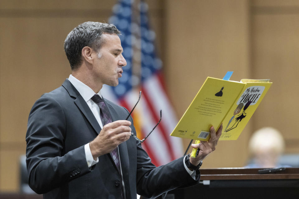 Attorney Craig Goodmark, representing Cobb County teacher Katie Rinderle reads from a copy of the children's book "My Shadow is Purple" during a hearing at the Cobb County Board of Education in Marietta, Ga., Thursday, Aug. 10, 2023. Rinderle is facing termination after reading "My Shadow is Purple," a book about gender identity, to fifth graders. (Arvin Temkar/Atlanta Journal-Constitution via AP)