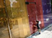 A boy tries to look past the opaque glass of an occupied toilet at the transparent public toilets that becomes opaque when occupied, designed by Japanese architect Shigeru Ban, at Yoyogi Fukamachi Mini Park in Tokyo