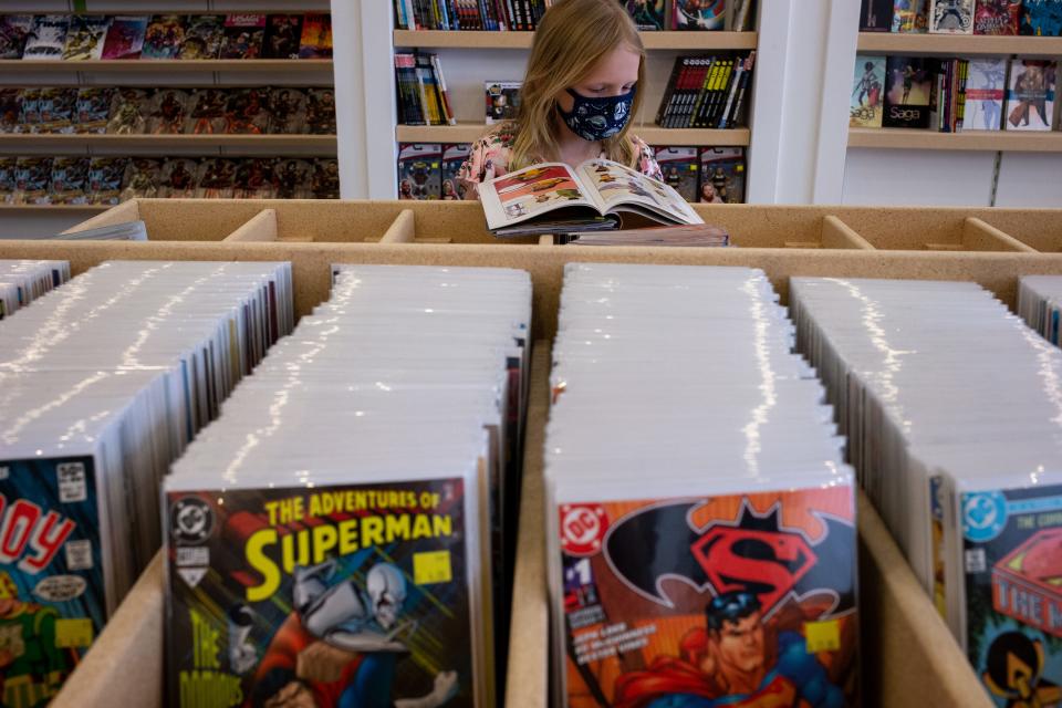 Evelyn Haeussler (8) looks at a comic book, Nov. 24, 2021, at Atomic Comics in Gilbert, Arizona.