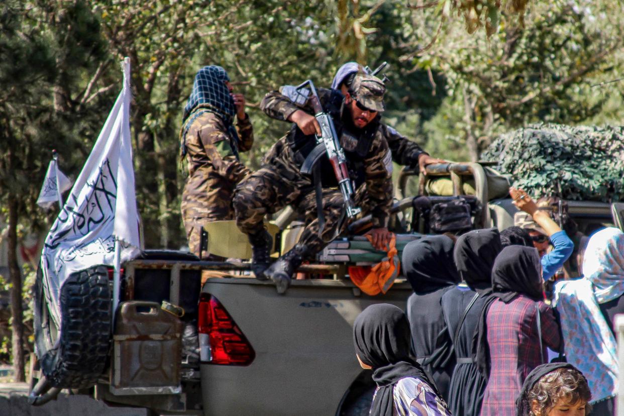 Taliban security forces confront Afghan women marching during a demonstration they call 