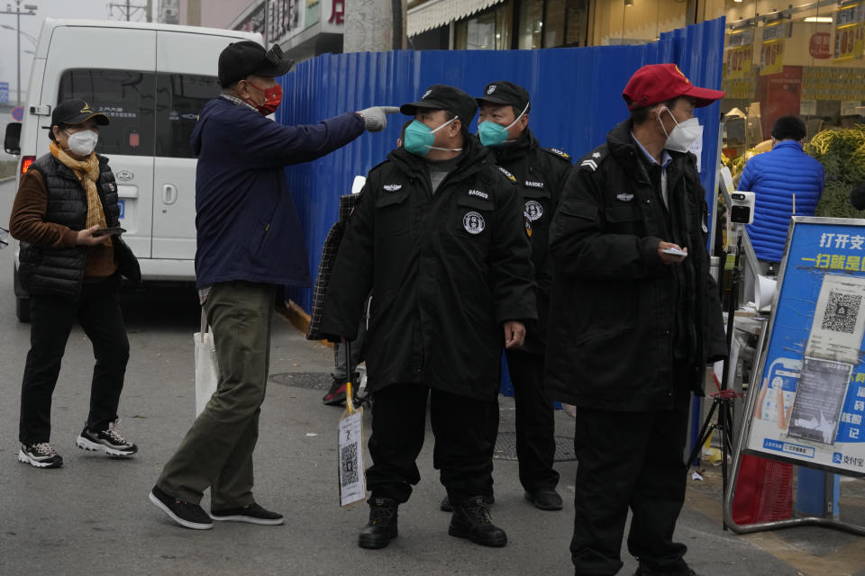 Security guards control access into a community under lockdown in Beijing, Thursday, Nov. 24, 2022. China is expanding lockdowns, including in a cental city where factory workers clashed this week with police, as its number of COVID-19 cases hit a daily record. (AP Photo/Ng Han Guan)