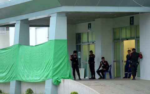 Police guard hospital where rescued boys are being kept for observation. The entrance was screened off to protect them from public view as they arrived - Credit: Tang Chhin Sothy/AFP