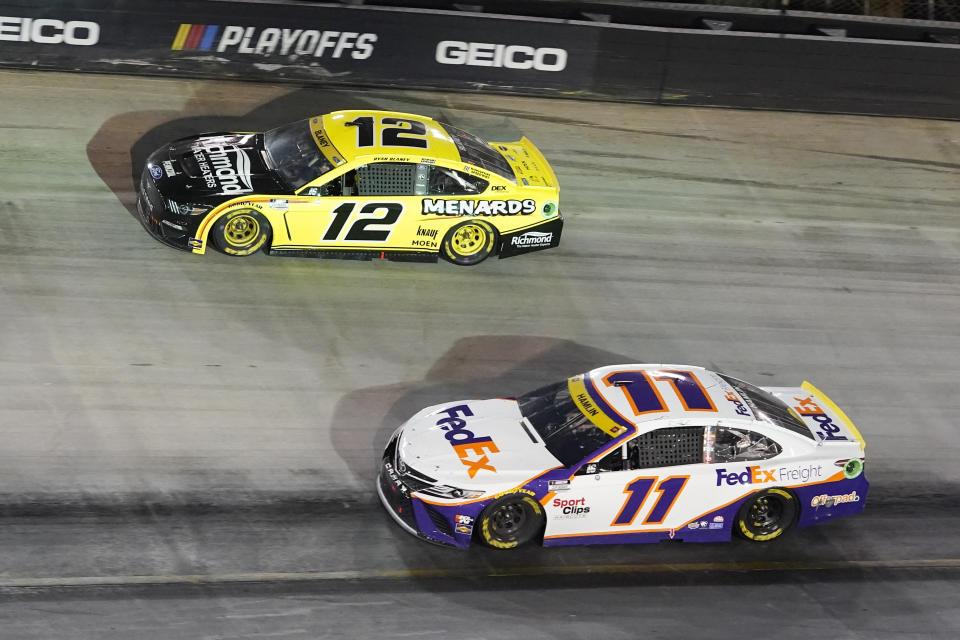 Ryan Blaney (12) and Denny Hamlin (11) come through a turn during a NASCAR Cup Series auto race at Bristol Motor Speedway Saturday, Sept. 18, 2021, in Bristol, Tenn. (AP Photo/Mark Humphrey)