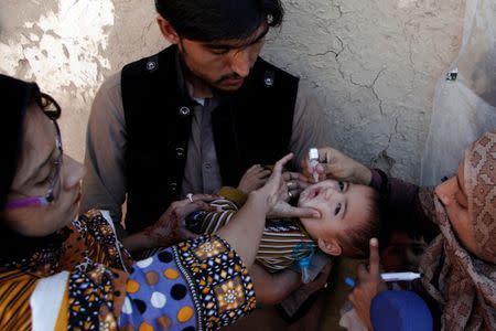 A boy receives polio vaccine drops by anti-polio vaccination workers along a street in Quetta, Pakistan January 2, 2017. REUTERS/ Naseer Ahmed