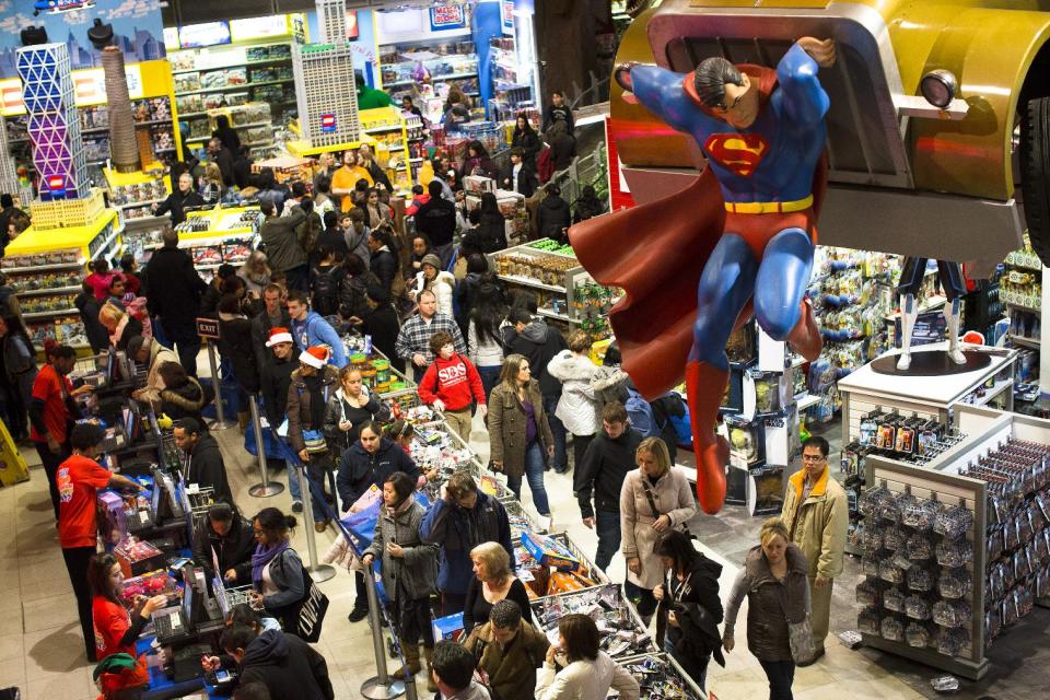 FILE - In this Thursday, Nov. 22, 2012, file photo, shoppers wait on a check-out line in the Times Square Toys-R-Us store after doors were opened to the public at 8 p.m., in New York. U.S. shoppers hit stores and websites at record numbers over the four-day Thanksgiving weekend, according to a survey released by the National Retail Federation on Sunday. They were attracted by retailers' efforts to make shopping easier, including opening stores on Thanksgiving evening, updating mobile shopping applications for smartphones and tablets, and expanding shipping and layaway options. (AP Photo/John Minchillo)