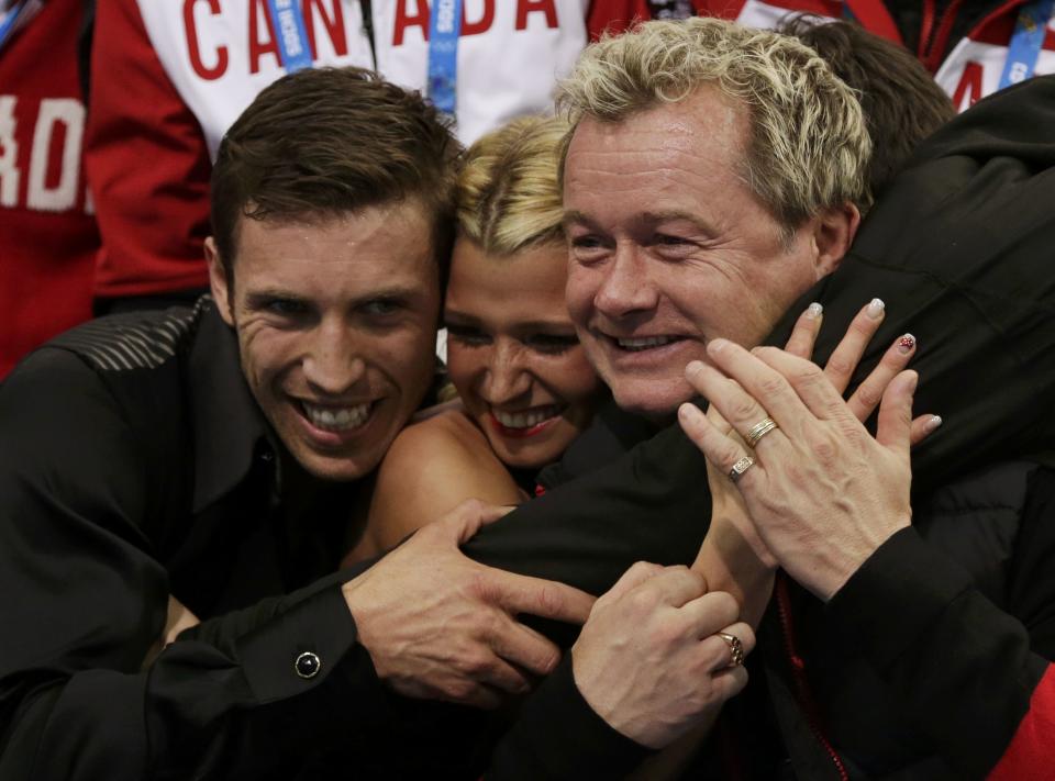 Kirsten Moore-Towers and Dylan Moscovitch (L) of Canada react with their coach Kris Wirtz (R) in the "kiss and cry" area during the Team Pairs Free Skating Program at the Sochi 2014 Winter Olympics, February 8, 2014. REUTERS/Darron Cummings/Pool (RUSSIA - Tags: SPORT FIGURE SKATING SPORT OLYMPICS)