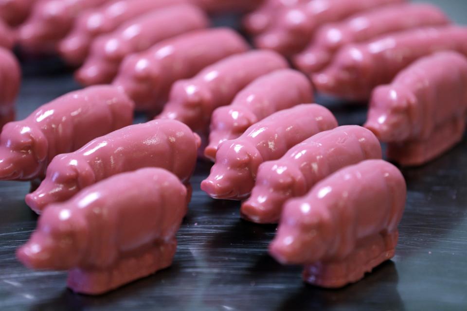 In this Dec. 6, 2012, photo, peppermint pigs are lined up after being removed from a mold at Saratoga Sweets in Halfmoon, N.Y. A holiday tradition in upstate New York has a peppermint twist: pig-shaped hard candies are sold with little metal hammers to be smashed at Christmas. (AP Photo/Mike Groll)