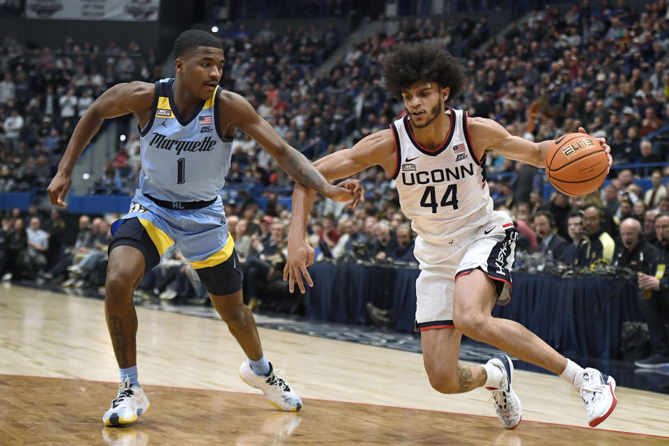 UConn's Andre Jackson Jr. (44) dribbles as Marquette's Kam Jones (1) defends in the second half of an NCAA college basketball game, Tuesday, Feb. 7, 2023, in Hartford, Conn. (AP Photo/Jessica Hill)