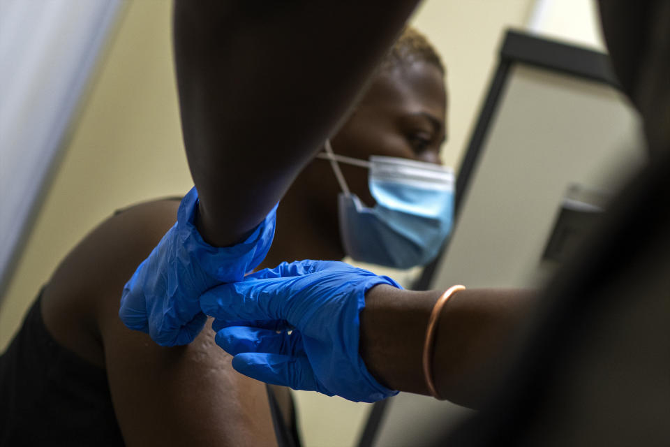 Volunteer Thabisle Khlatshwayo, who received her first shot for a COVID-19 vaccine trial, receives her second shot at a vaccine trial facility set at Soweto's Chris Sani Baragwanath Hospital outside Johannesburg, South Africa, Monday Nov. 30, 2020. Over 2000 South African volunteers are on AstraZeneca's experimental coronavirus vaccine trial. (AP Photo/Jerome Delay)