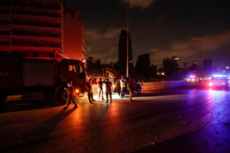 Members of the Lebanese Civil Defence stand outside a vehicle on the side of a road near the port of Lebanon's capital Beirut in the aftermath of a massive explosion, on August 4, 2020. - Two huge explosion rocked the Lebanese capital Beirut, wounding dozens of people, shaking buildings and sending huge plumes of smoke billowing into the sky. Lebanese media carried images of people trapped under rubble, some bloodied, after the massive explosions, the cause of which was not immediately known. (Photo by JOSEPH EID / AFP) (Photo by JOSEPH EID/AFP via Getty Images)