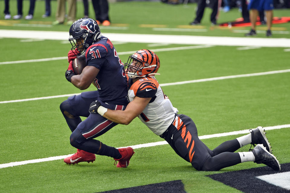 El running back David Johnson (31), de los Texans de Houston, atrapa un pase de touchdown ante el linebacker Markus Bailey, de los Bengals de Cincinnati, en el juego de NFL del domingo 27 de diciembre de 2020, en Houston. (AP Foto/Eric Christian Smith)