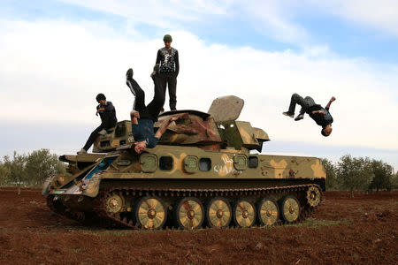 Muhannad al-Kadiri (R),18, and Ibrahim Eid, 16, demonstrate their Parkour skills over a military vehicle in the rebel-held city of Inkhil, west of Deraa, Syria, February 4, 2017. REUTERS/Alaa Al-Faqir