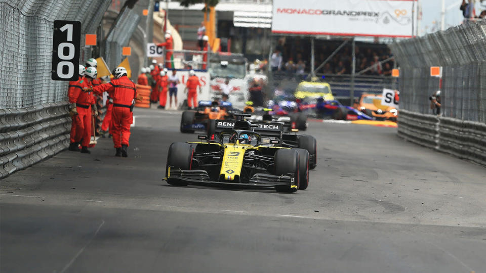 F1 Grand Prix of Monte Carlo, race day; Marshalls clear the circuit from debris while Renault Sport F1 Team, Daniel Ricciardo passes them (photo by Octane/Action Plus via Getty Images)