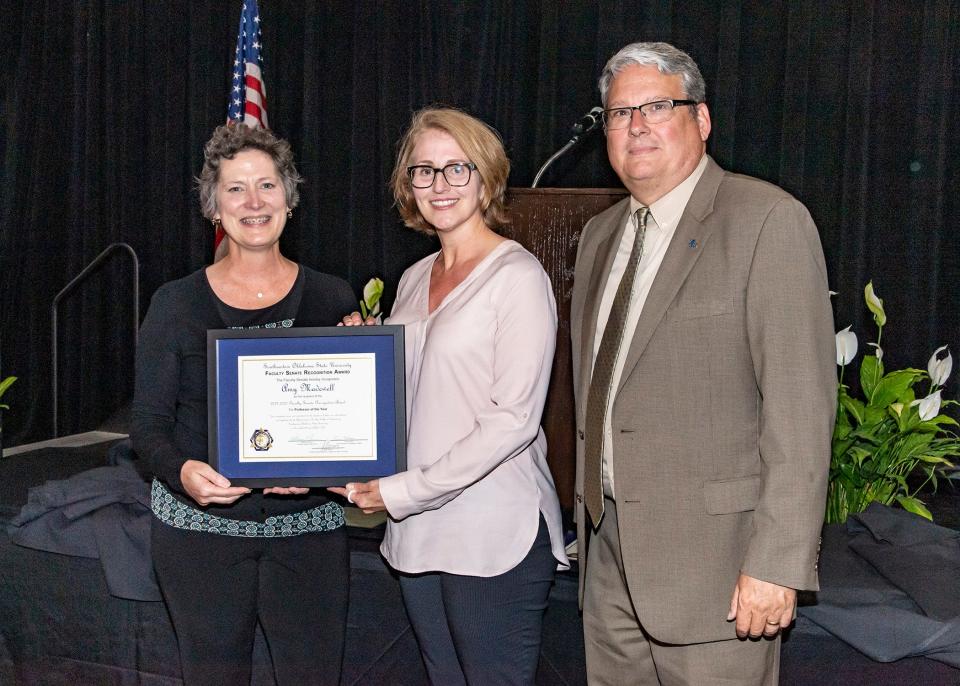 Faculty Senate Professor of the Year Dr. Amy Madewell is congratulated by Dr. Katheryn Shannon and SE president Thomas Newsom.