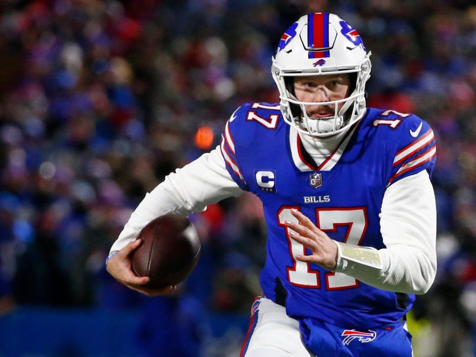 Josh Allen runs with the ball during a game against the New England Patriots.