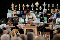 A man dressed in traditional clothes tries to pull his opponent over the table at the German Championships in Fingerhakeln or finger wrestling, in Bernbeuren, Germany, Sunday, May 12, 2024. Competitors battled for the title in this traditional rural sport where the winner has to pull his opponent over a marked line on the table. (AP Photo/Matthias Schrader)