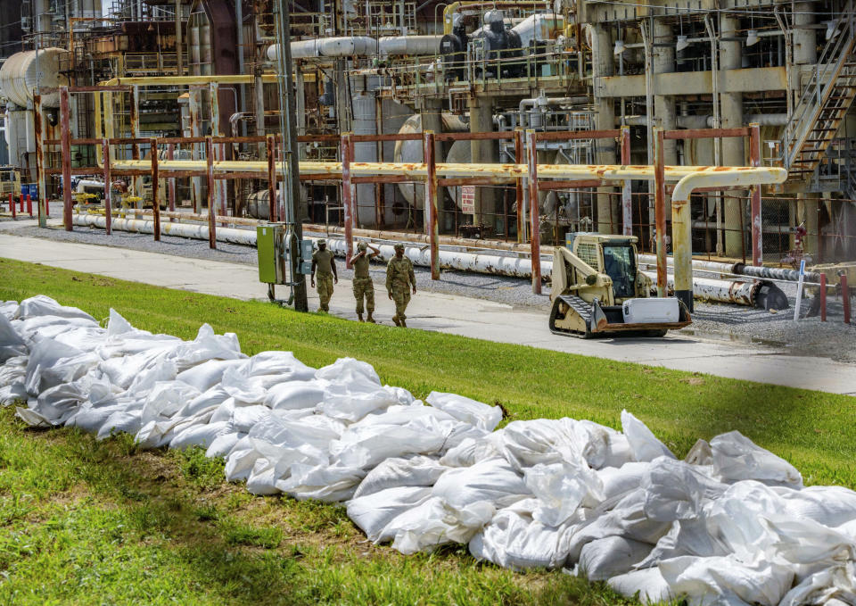 FILE - In this Thursday, July 11, 2019, file photo, soldiers with the U.S. Army National Guard work on adding sandbags to levees by the Chalmette Refining plant in Chalmette, La., ahead of Tropical Storm Barry. Barry could harm the Gulf Coast environment in a number of ways. But scientists say it’s hard to predict how severe the damage will be. (AP Photo/Matthew Hinton, File)