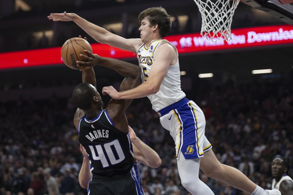 Sacramento Kings forward Harrison Barnes (40) makes a layup while being fouled by Los Angeles Lakers guard Austin Reaves, right, in the first half of an NBA basketball game, Sunday, Oct. 29, 2023, in Sacramento, Calif. (Sara Nevis/The Sacramento Bee via AP)