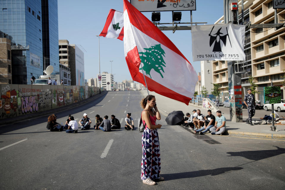 A woman holds a Lebanese flag as she stands at a roadblock during ongoing anti-government protests in Beirut, Lebanon November 4, 2019. REUTERS/Andres Martinez Casares     TPX IMAGES OF THE DAY