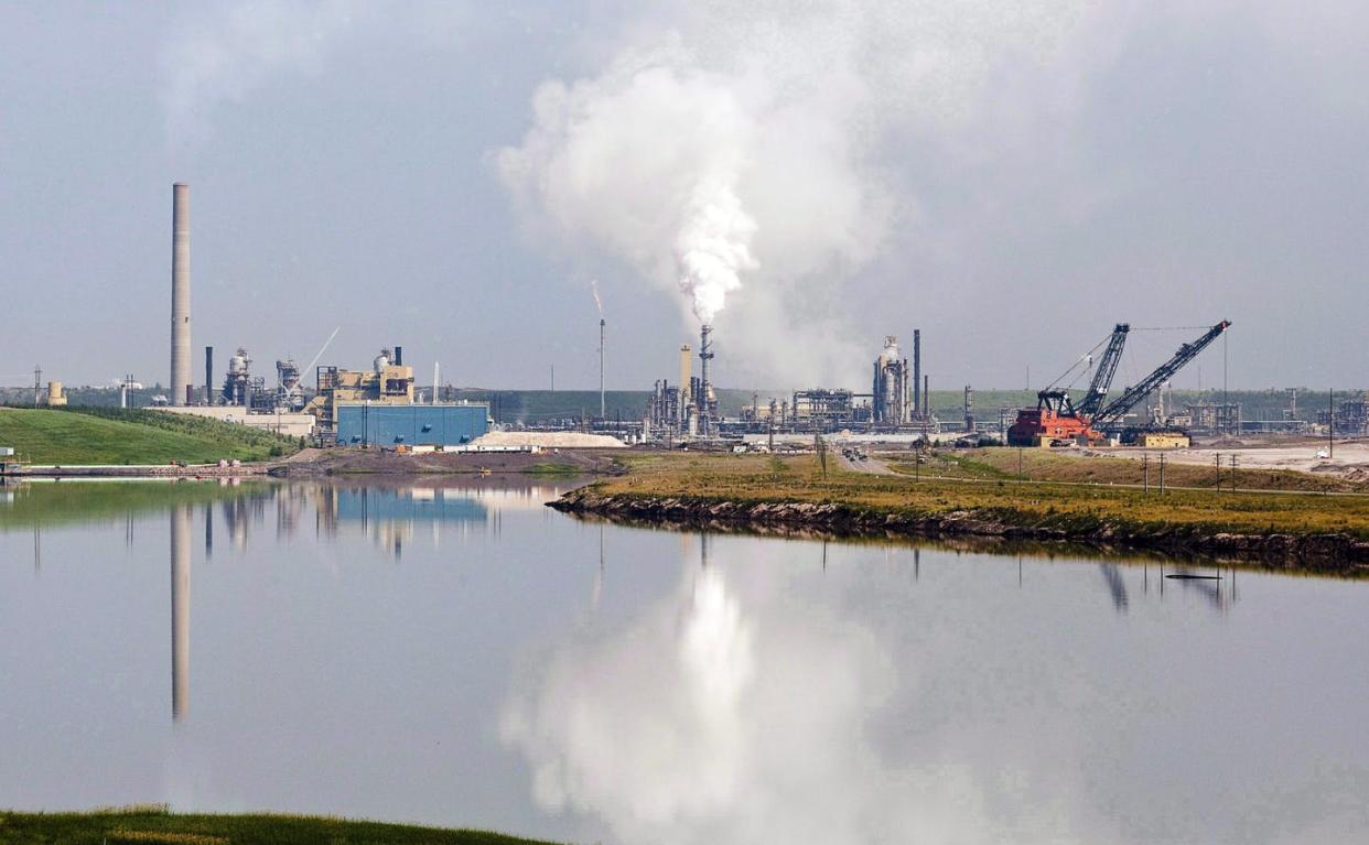 <span class="caption">A tailings pond at an oilsands facility near Fort McMurray, Alta., in July 2012. The estimated cost of reclaiming oilsands mines is almost $31 billion. </span> <span class="attribution"><span class="source">THE CANADIAN PRESS/Jeff McIntosh </span></span>