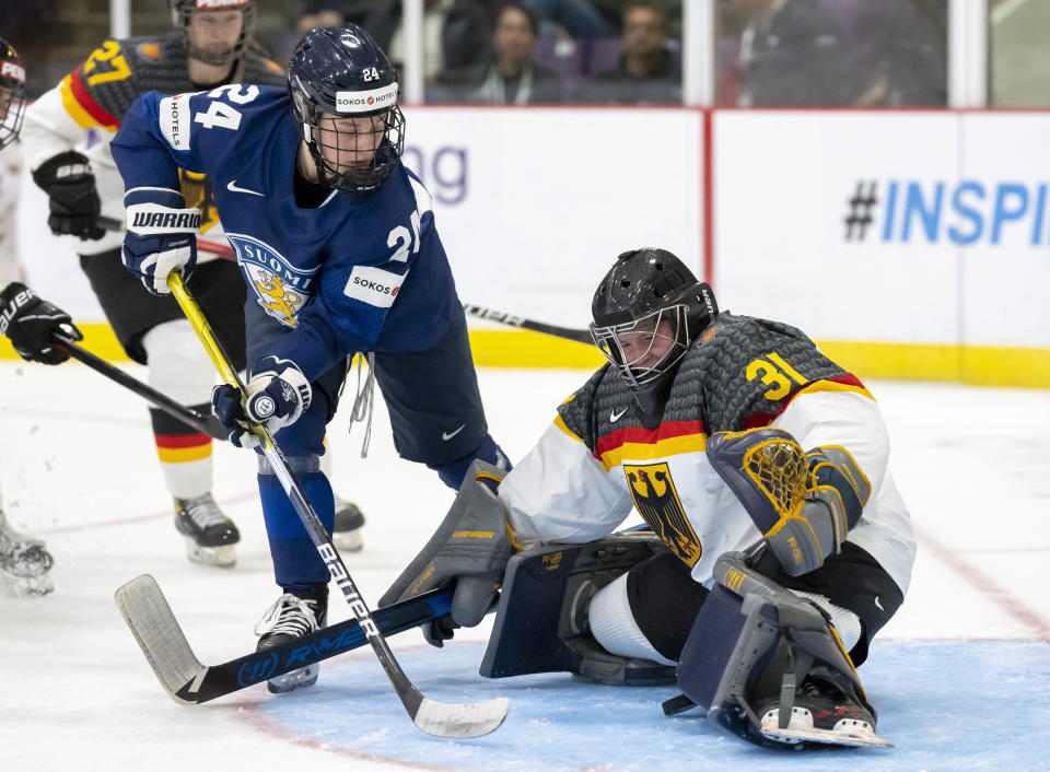Germany goaltender Johanna May (31) makes a save against Finland forward Viivi Vainikka (24) during the third period of a match at the Women's World Hockey Championships in Brampton, Ontario, Friday, April 7, 2023. (Frank Gunn/The Canadian Press via AP)