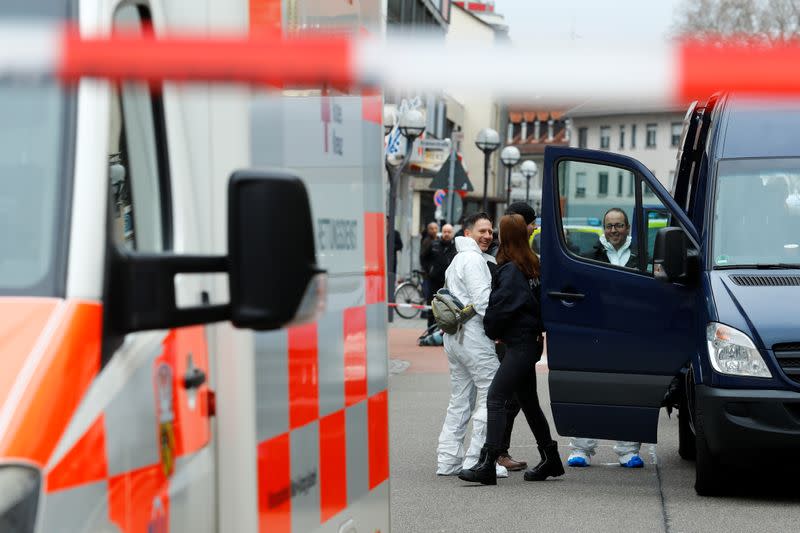 Police officers and forensic investigators are seen outside the Midnight Shisha bar after a shooting in Hanau