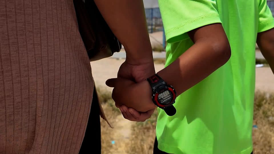 Hoda Muthana holds hands with her 7-year-old son at the Al-Roj detention camp in northeastern Syria. - CNN