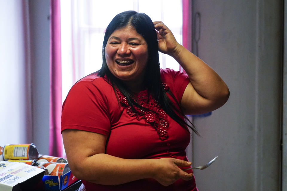 Keldy Mabel Gonzales Brebe smiles as she makes a meal for her family in the Kensington section of Philadelphia, Sunday, May 16, 2021. Gonzales Brebe, a 37-year-old Honduran immigrant, and her two teenage sons are trying to rebuild their lives together after they were separated under a former "zero-tolerance" policy to criminally prosecute adults who entered the country illegally. (AP Photo/Matt Rourke)