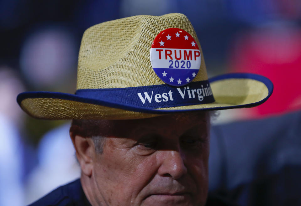 A supporter wears a campaign button on his hat as he waits for President Donald Trump to speak at a rally at WesBanco Arena, Saturday, Sept. 29, 2018, in Wheeling, W.Va. (AP Photo/Pablo Martinez Monsivais)