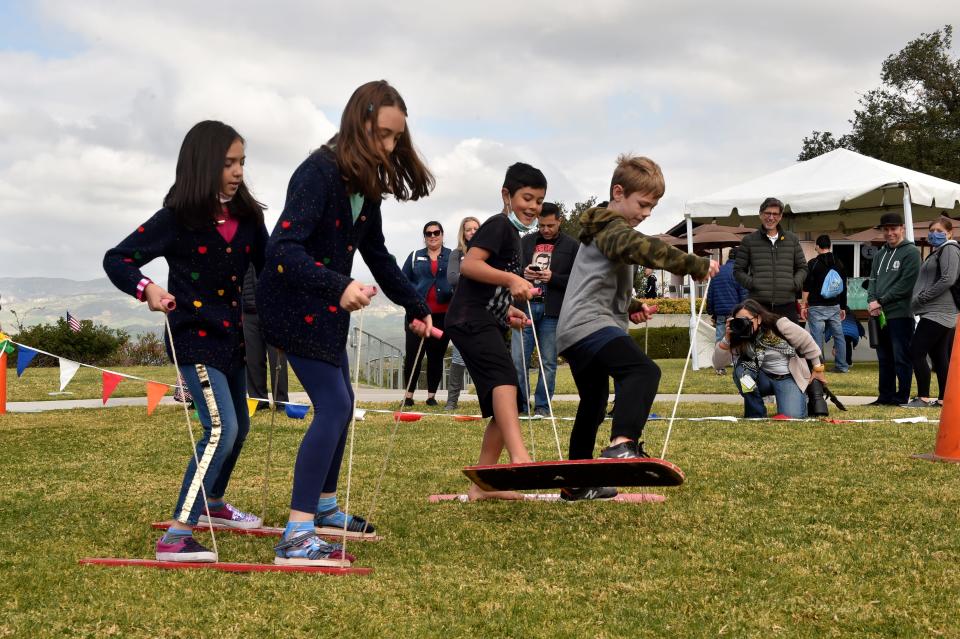Sisters Guilia and Sofia Ciriani, from left, catch up to Joey Fils and partner Logan Sterkel in the buddy walkers race during the Presidents Day celebration at the Ronald Reagan Presidential Library & Museum on Feb. 21, 2022.