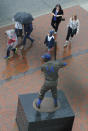 CHICAGO, IL - AUGUST 09: People walk past the Ernie Banks statue during a rain storm before a game between the Chicago Cubs and the Cincinnati Reds on August 9, 2012 at Wrigley Field in Chicago, Illinois. The game has been delayed due to rain. (Photo by David Banks/Getty Images)